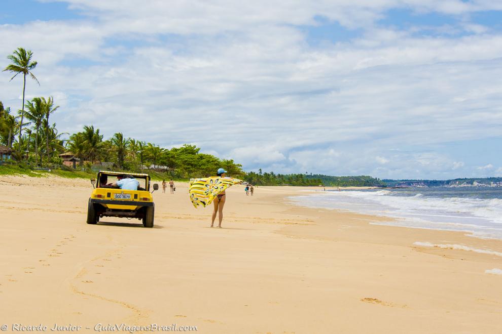 Imagem de turistas ao lado do buggy amarelo na Praia de Caraiva.